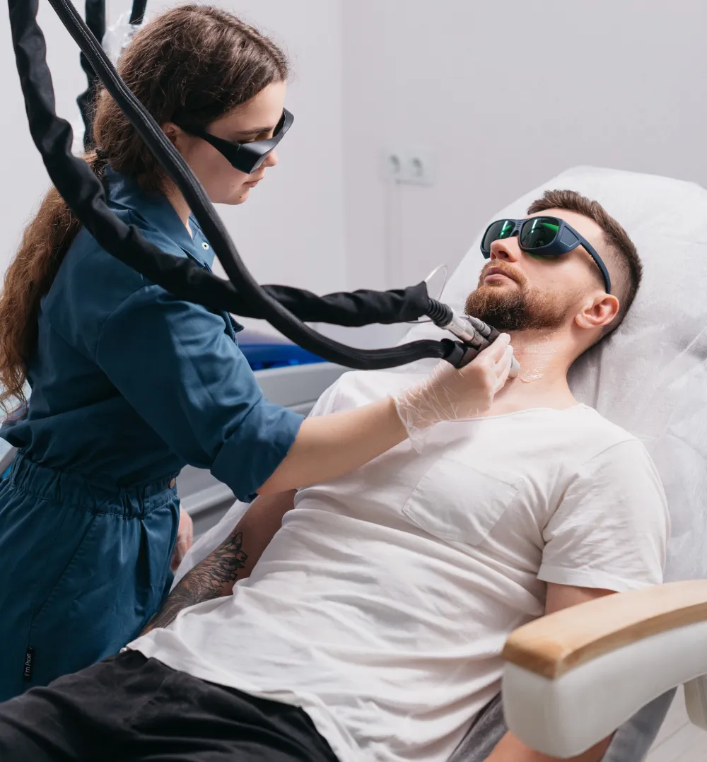 Specialist performing a laser facial on a male client at Laser & More Clinic, Dubai